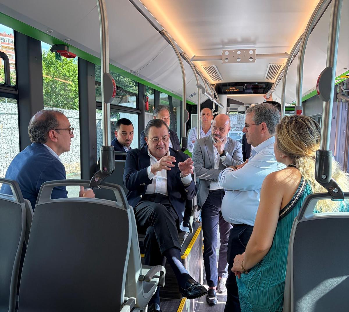 La comitiva examina el interior del primer autobús articulado eléctrico de la red urbana de Cáceres.