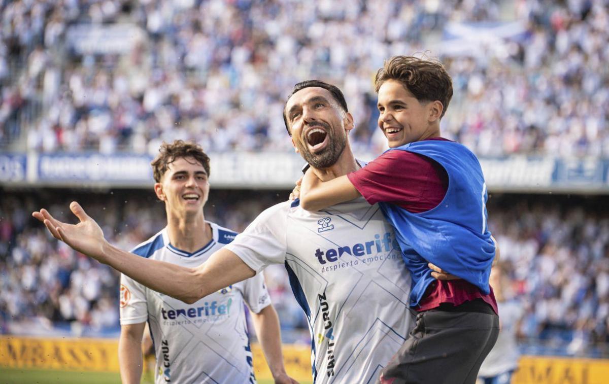 Enric Gallego celebra el ascenso con su hijo ante la mirada de Dani Fernández. | ARTURO JIMÉNEZ