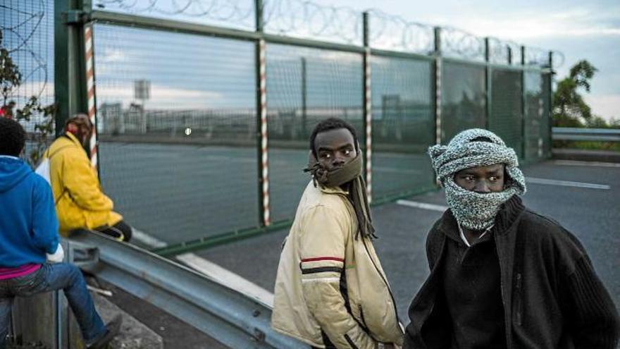 Un grup d&#039;immigrants, a Calais, esperant que passi el tren per intentar arribar al Regne Unit