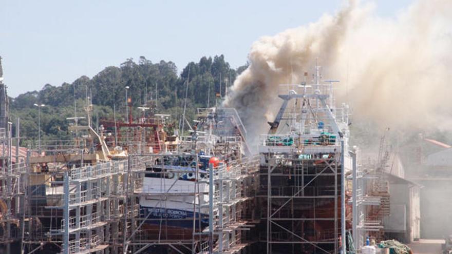 Fuego en un barco en el astillero de Placeres. //S. Álvarez