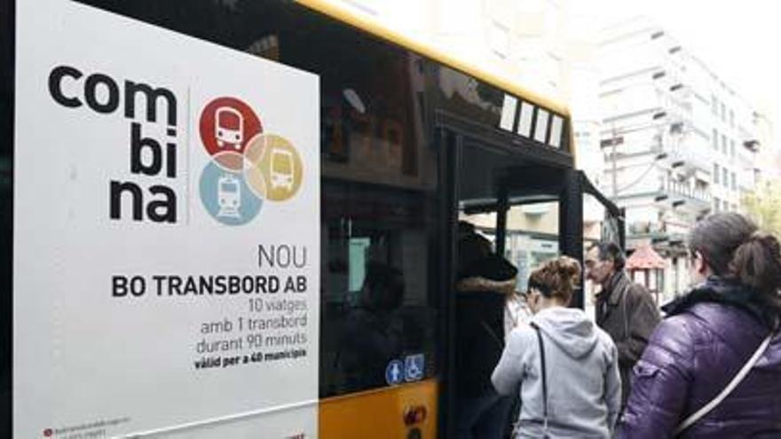 Usuarios del metrobús de una parada de Xirivella pasan ante el cartel que anuncia el nuevo bono.