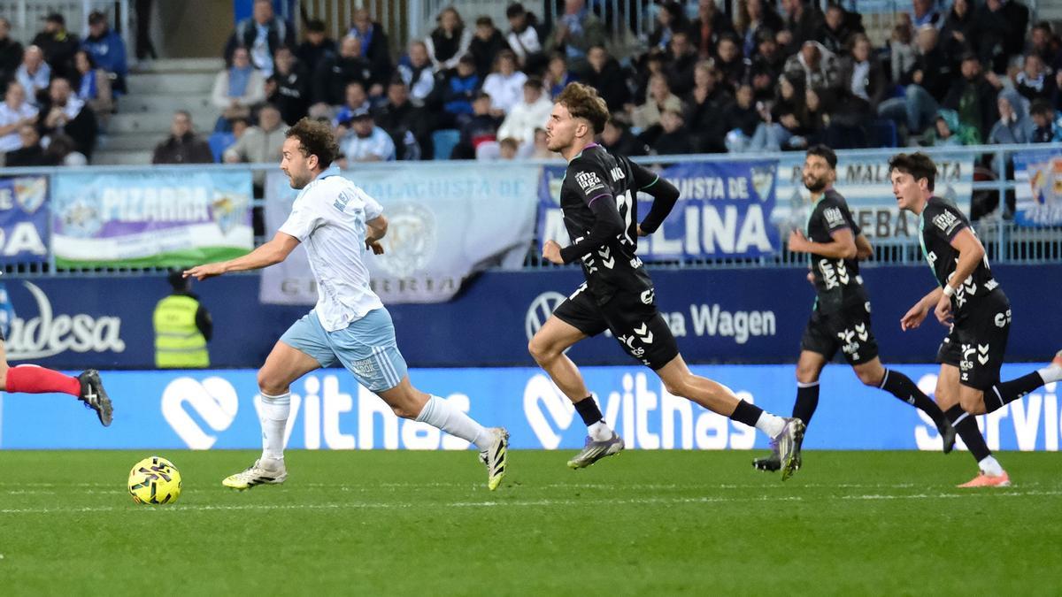 Keidi Bare conduce el balón perseguido por varios jugadores del Málaga.