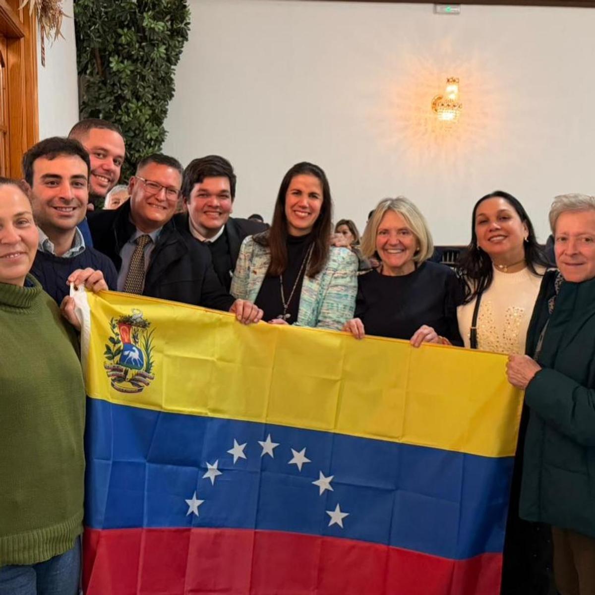 En el centro, la alcaldesa de Bétera, Elia Verdevío, junto a la bandera venezolana que se mostró en la cena del PP provincial en Alzira.