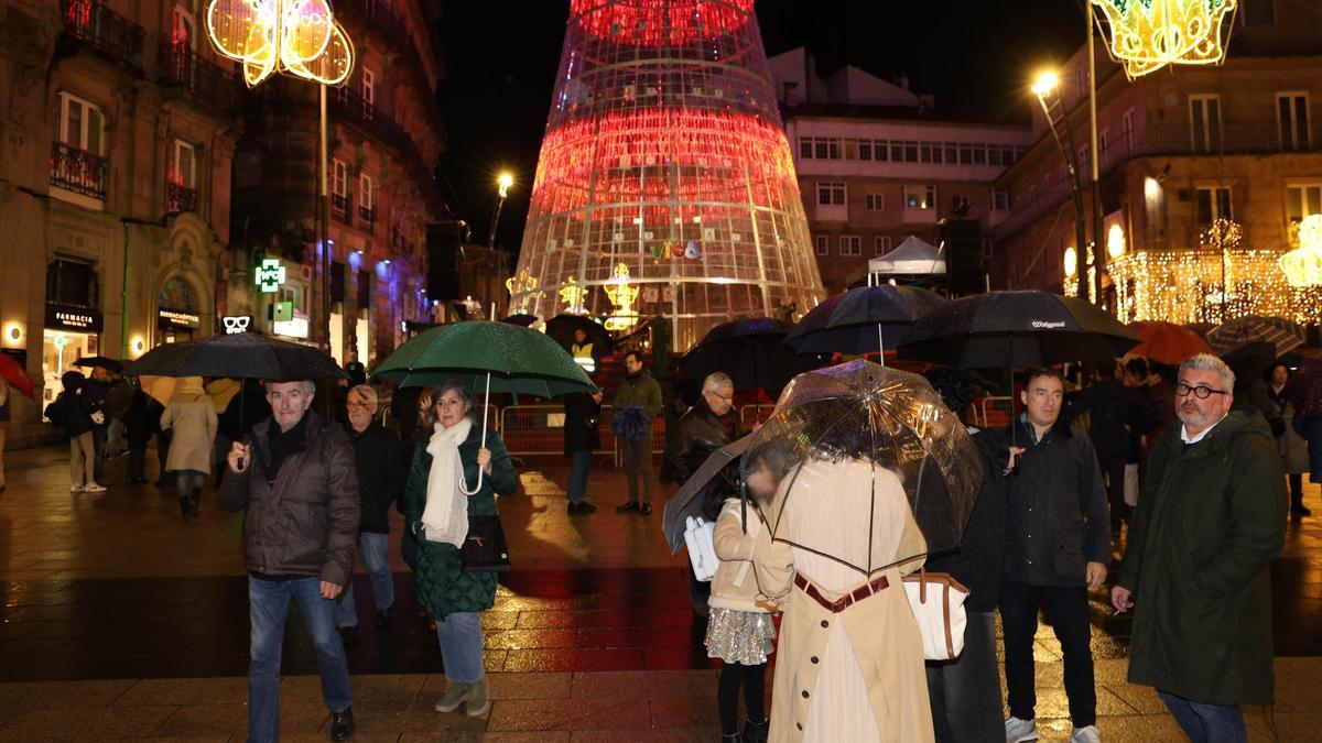Visitantes con paraguas en los últimos días de las luces de Navidad en Vigo en el mes de enero