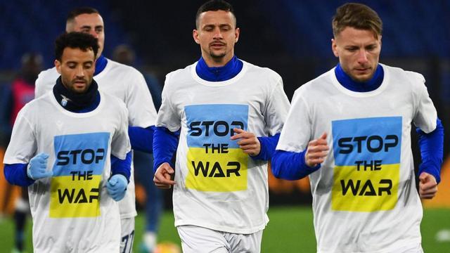 Lazio's Italian forward Ciro Immobile (R) and teammates wear a 'Stop the war' T-shirts referring to Russia's invasion of the Ukraine as they arrive to warm-up prior to the Italian Serie A football match between Lazio and Napoli at the Olympic stadium, in Rome on February 27, 2022. (Photo by Vincenzo PINTO / AFP)