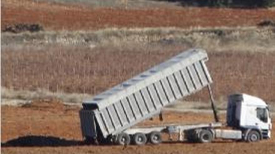Un camión deposita lodos en un campo de Requena.