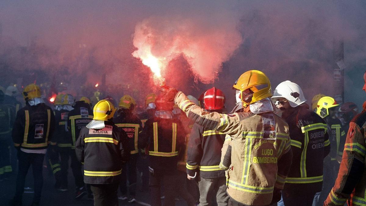 Un bombero se prende fuego en la plaza do Obradoiro durante la protesta de los comarcales