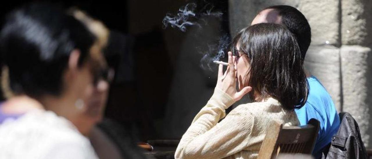 Una imagen de archivo de una mujer fumando en una plaza de Pontevedra. |   // RAFA VÁZQUEZ