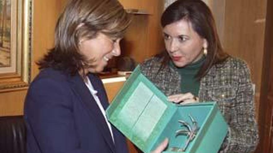 La alcaldesa de Elche, Mercedes Alonso (d), entrega una palmera de plata, símbolo de la ciudad, a la ministra de Sanidad, Servicios Sociales e Igualdad, Ana Mato, que ha visitado hoy el ayuntamiento alicantino.