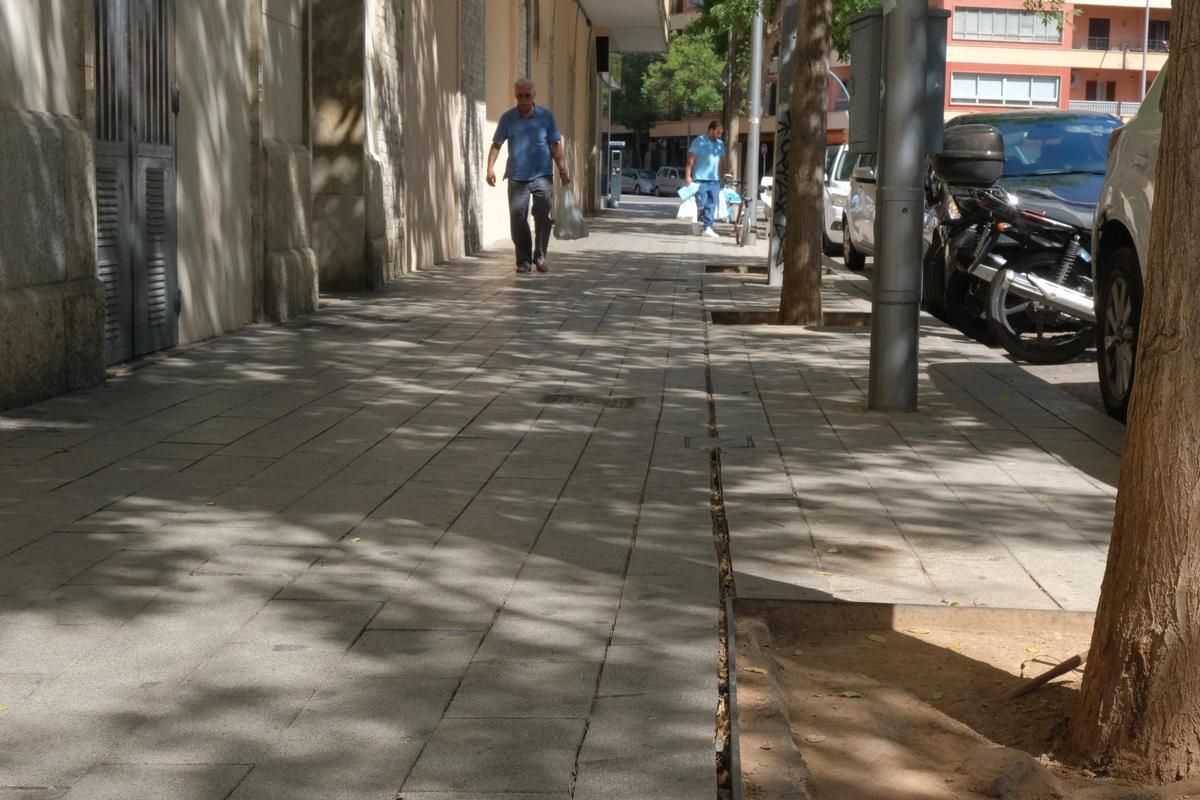 Un ciudadano camina por el tramo de la calle Joan Alcover de Palma con las baldosas sueltas