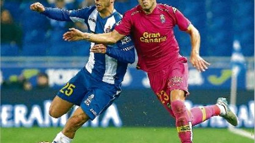 Marco Asensio prova de conduir la pilota davant la pressió del jugador de Las Palmas Javi Castellano.