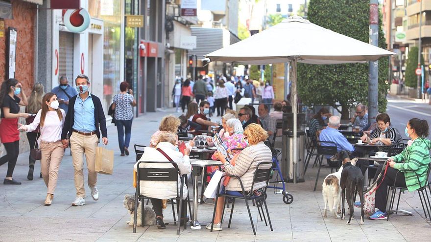 Público ocupando las mesas de un establecimiento de hostelería en el centro de Alicante.