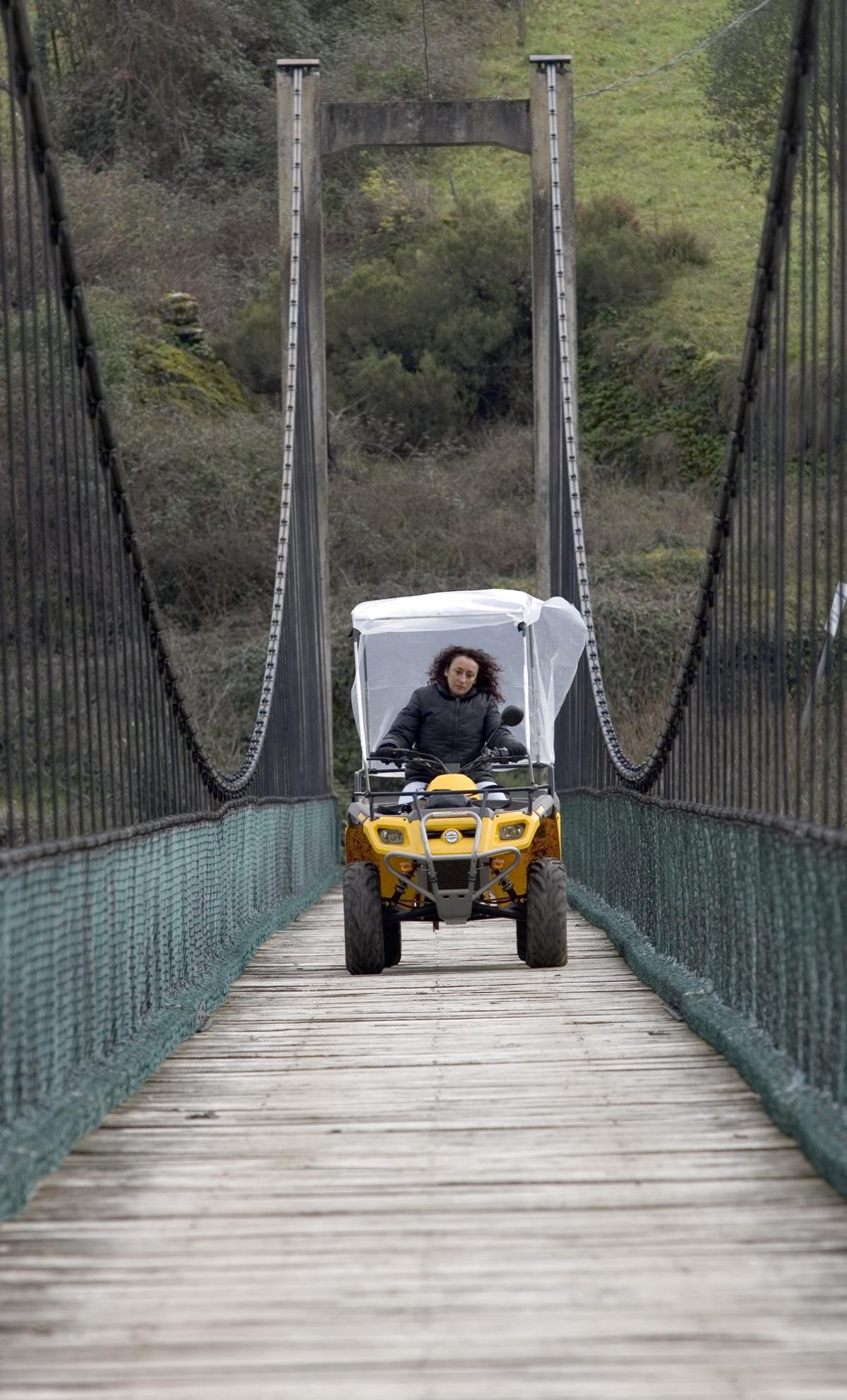 Elma Andrés cruza el puente que lleva a Riodeporcos en su quad