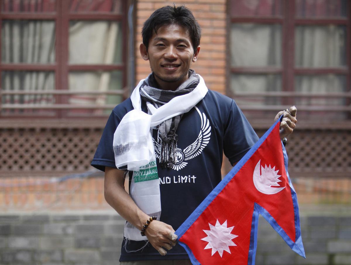 FILE- In this Aug. 23, 2015 file photo, Japanese climber Nobukazu Kuriki poses with a Nepalese flag during a press conference as he attempts to be the first to scale Mount Everest since the April 2015 earthquake that killed 19 mountaineers, in Kathmandu, Nepal. Kuriki and another foreign climber attempting to scale Mount Everest have died on the world’s highest peak, a Nepal mountaineering official said Monday, May 21, 2018. (AP Photo/Bikram Rai, File)