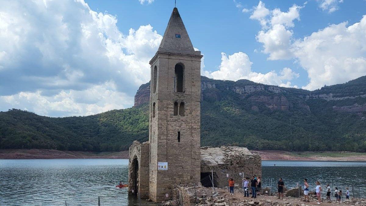 Turistas se acercan a ver la iglesia del pantano de Sau.