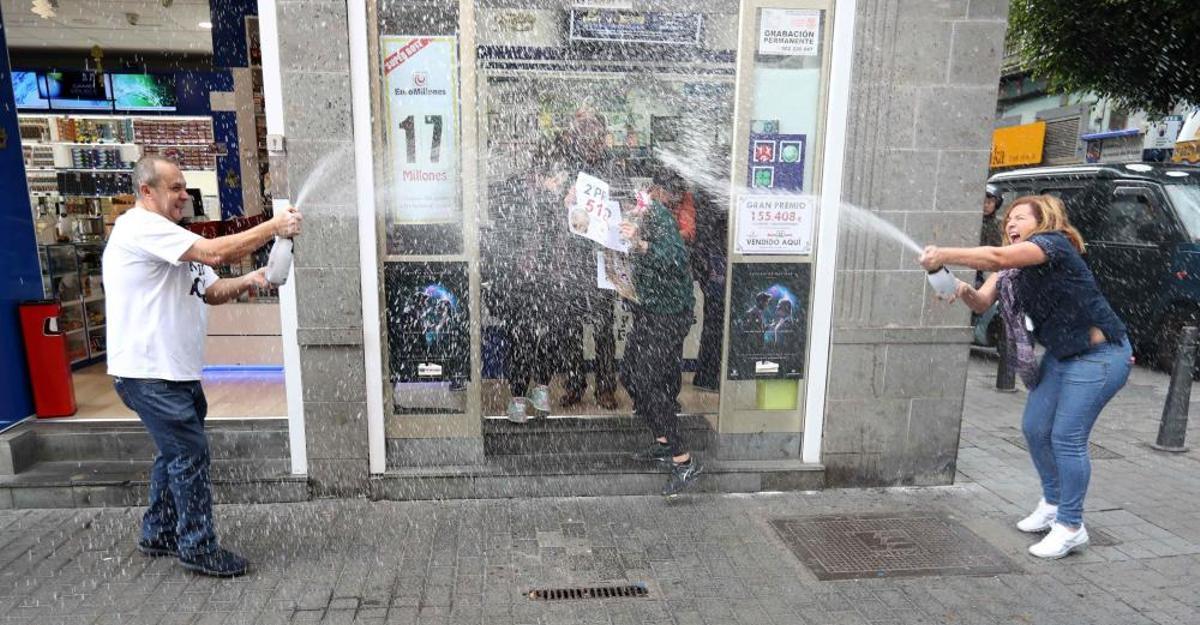 Los propietarios de la administración de lotería de la calle Ripoche en Las Palmas de Gran Canaria celebran el segundo premio vendido en su oficina y que ha recaído en el número 51244. EFE