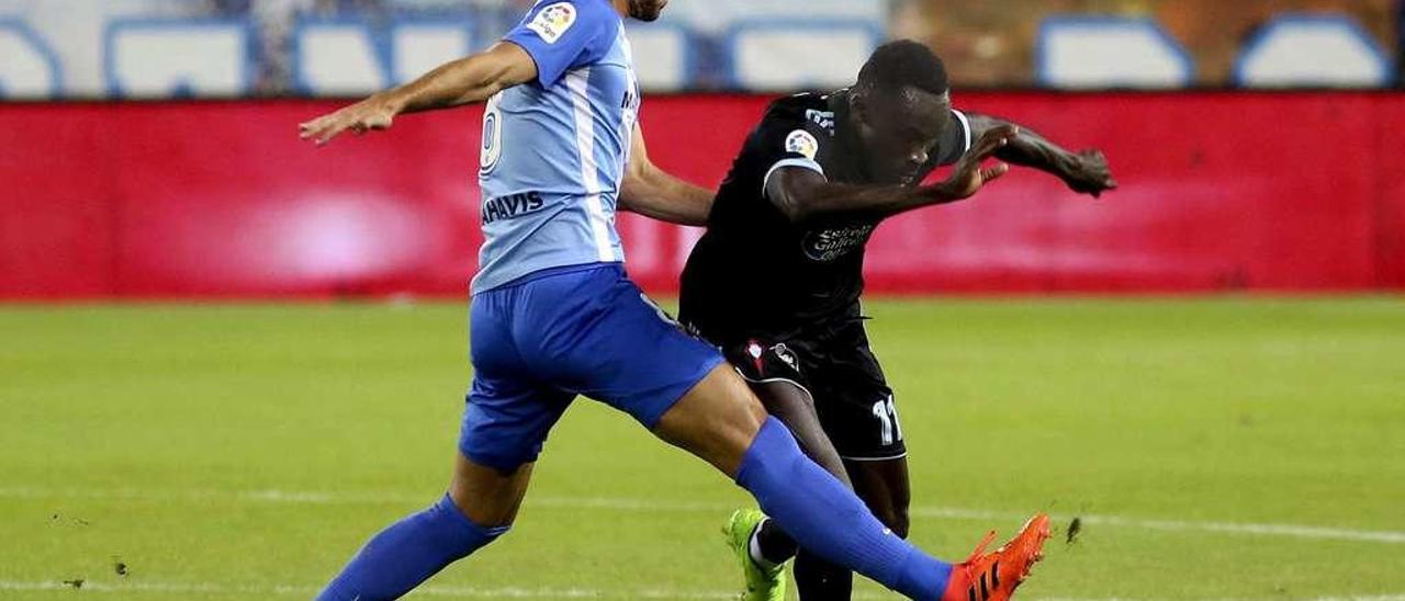 Adrián González disputa un balón a Pione Sisto durante el choque disputado anoche en La Rosaleda entre el Málaga y el Celta. // Efe