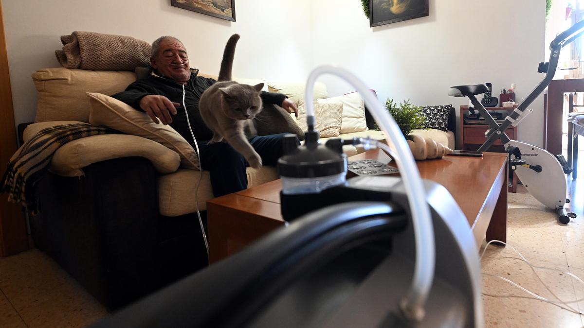 Barcelona 15.12.2022. Sociedad. Salvador Mañosas, enfermo de EPOC, conectado a una máquina en su domicilio junto a su gato Tom ( para reportaje sobre probreza energética al multiplicarse la factura de luz por estar conectado las 24 horas del día a una máquina). Fotografía de Jordi Cotrina