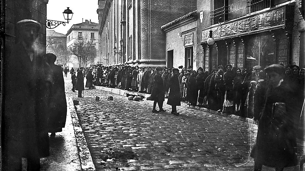 Invernal imagen esquinera entre las calles del Pilar y de Fernando el Católico por donde transita la fila de quienes aguardaban para ver los restos mortales de Joaquín Costa en la Casa Consistorial en 1911