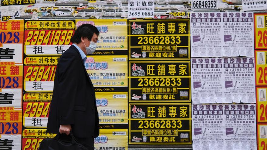 Un home camina pel carrer amb mascareta a Hong Kong