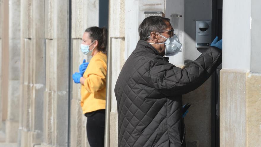 Un malagueño hace sus gestiones con mascarilla.