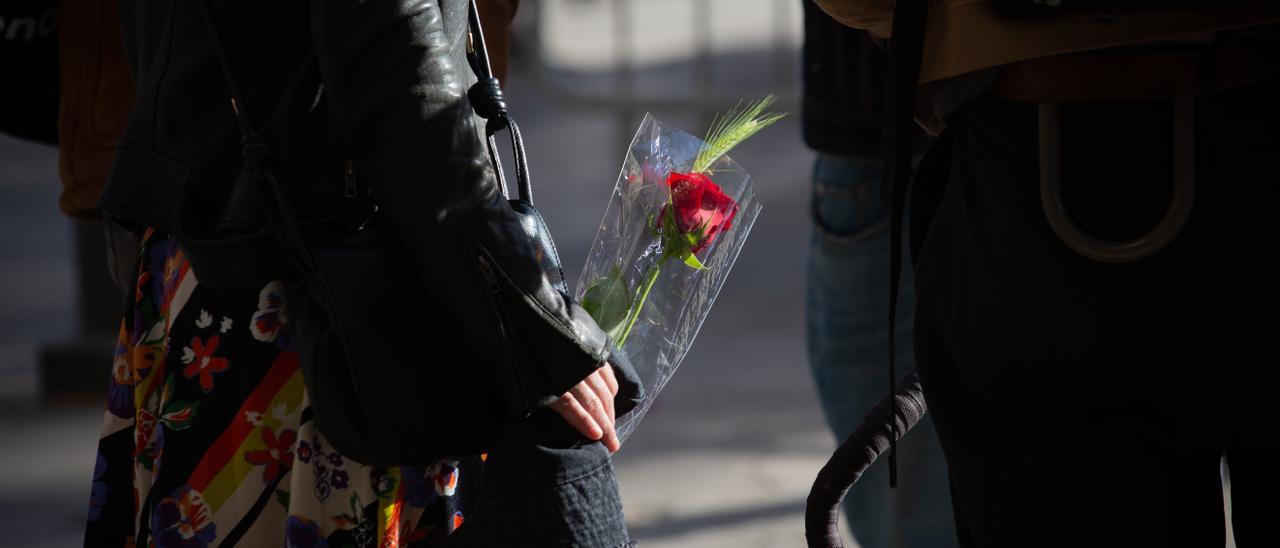 Archivo - Una mujer con una rosa en la Plaza Real de Barcelona en el día de Sant Jordi, a 23 de abril de 2021, en Barcelona