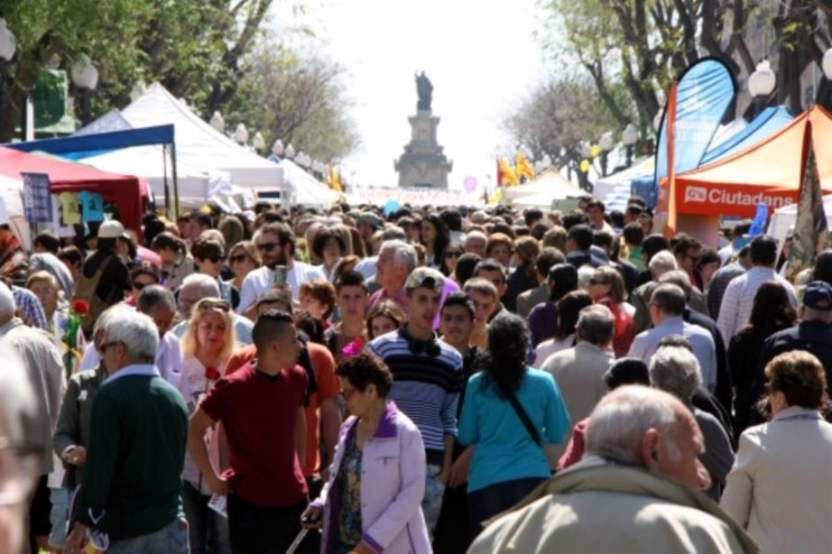 Milers de persones passegen per la Rambla Nova de Tarragona, durant la diada de Sant Jordi.