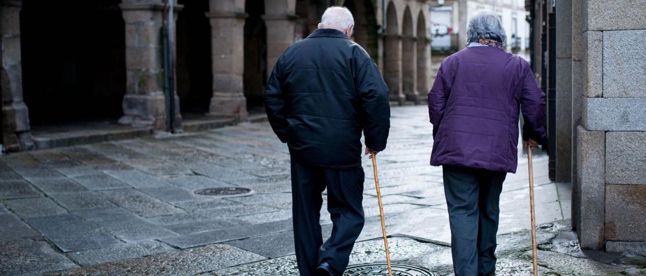 Dos personas mayores caminan por el casco histórico de Ourense. |   // BRAIS LORENZO