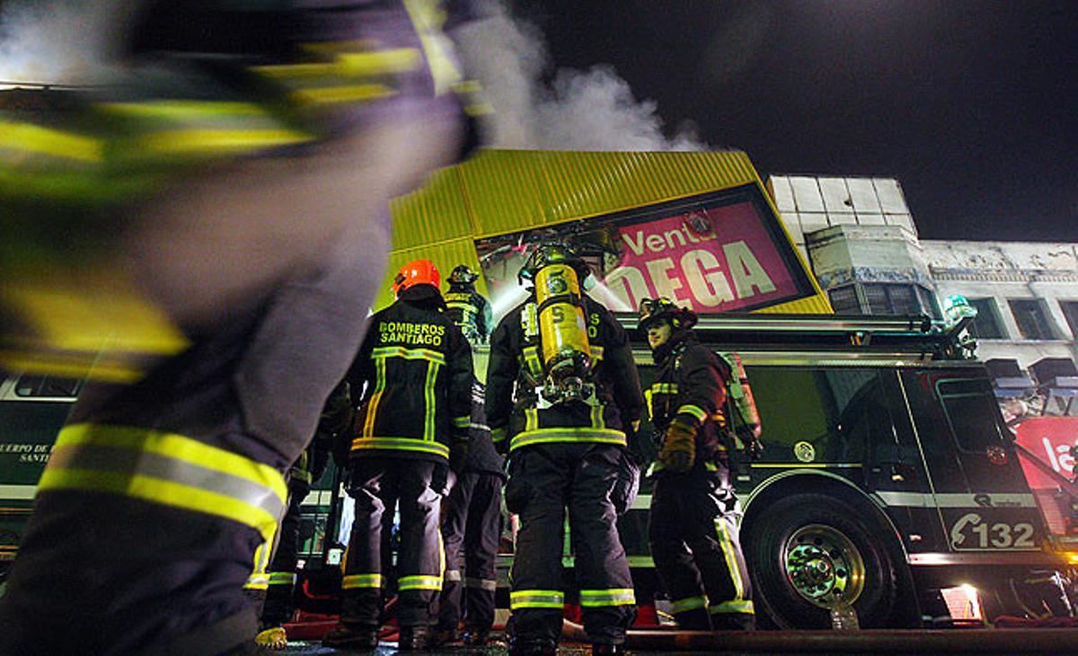Els bombers apaguen un incendi en un edifici de Santiago de Xile. El foc es va originar després d’una de les manifestacions estudiantils a la ciutat.