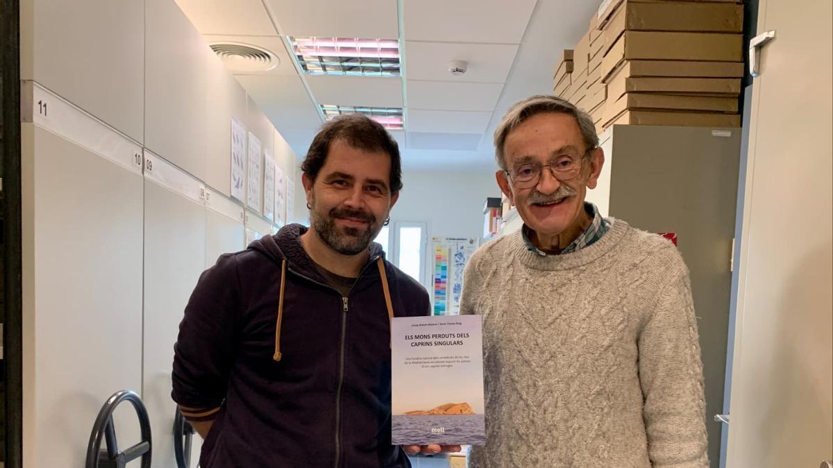 Enric Torres-Roig y Josep Antoni Alcover mostrando el libro 'Els mons perduts dels caprins singulars'