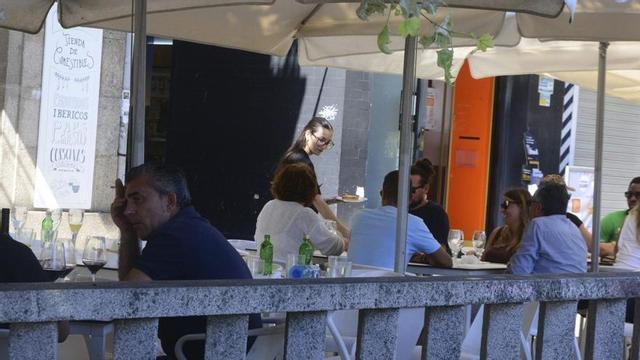 Una trabajadora de la hostelería atendiendo, este martes, en una terraza de Cangas. | GONZALO NÚÑEZ