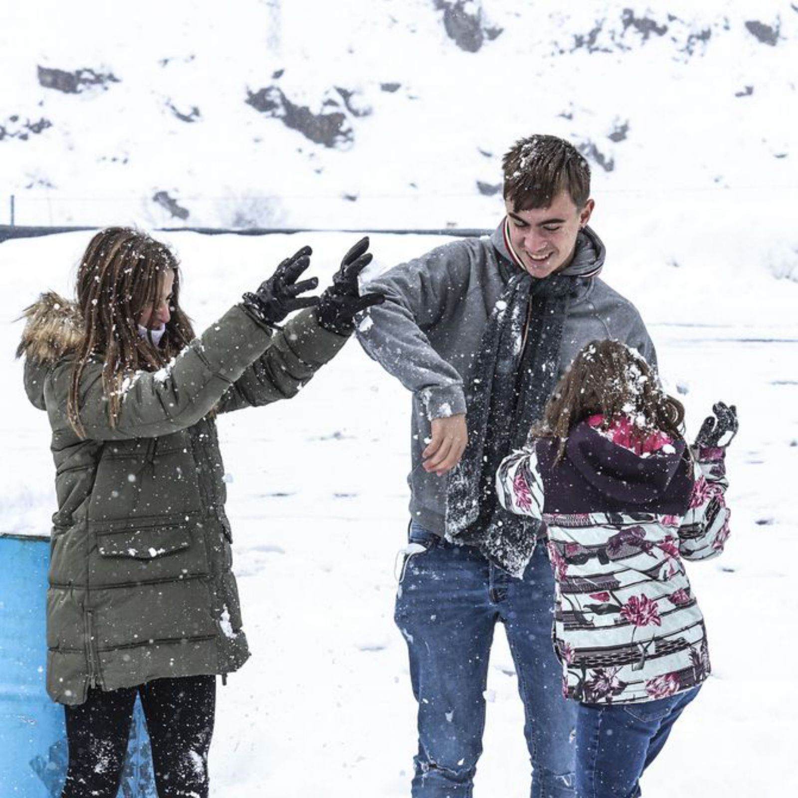 Los hermanos Claudia, Julio y Bárbara Apéstigue juegan con la nieve en la gasolinera del Huerna. | Irma Collín