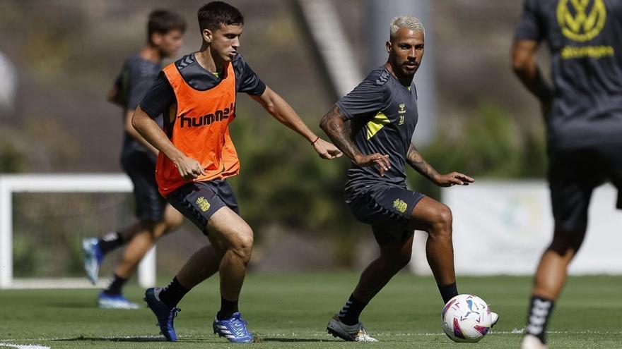 El mediapunta y capitán de la UD Las Palmas Jonathan Viera Ramos, ayer, durante la sesión de trabajo en Barranco Seco controla el esférico. A la izquierda, el centrocampista Máximo Perrone.
