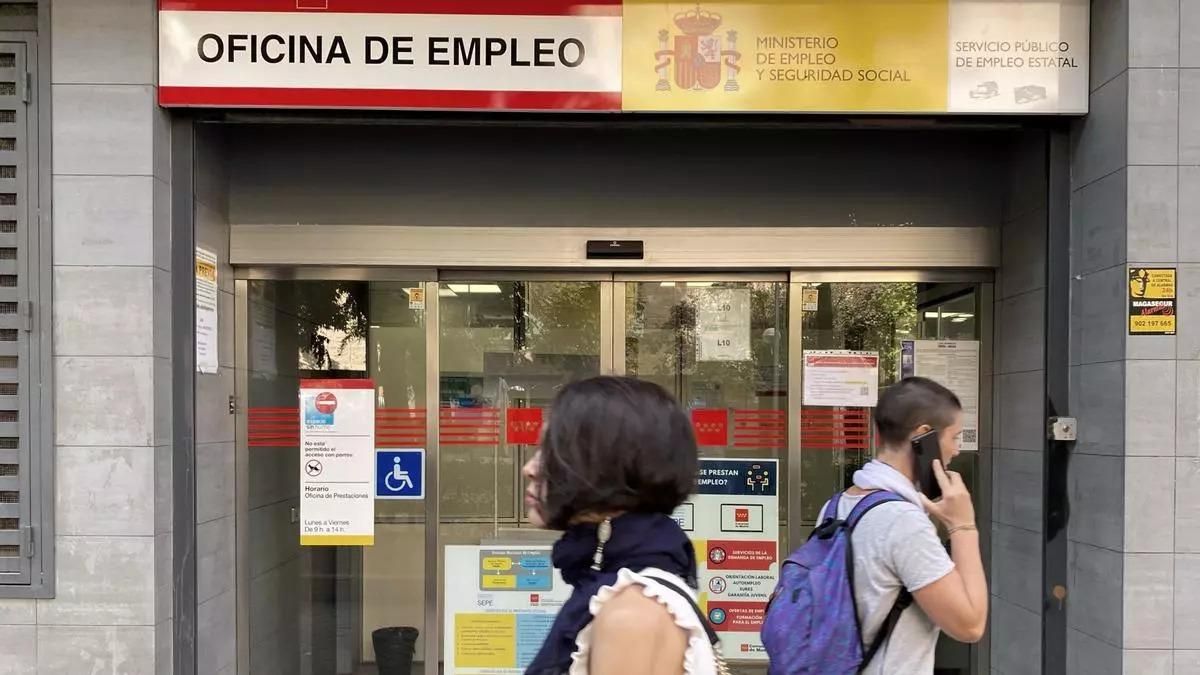 Dos jóvenes pasan por una oficina de empleo