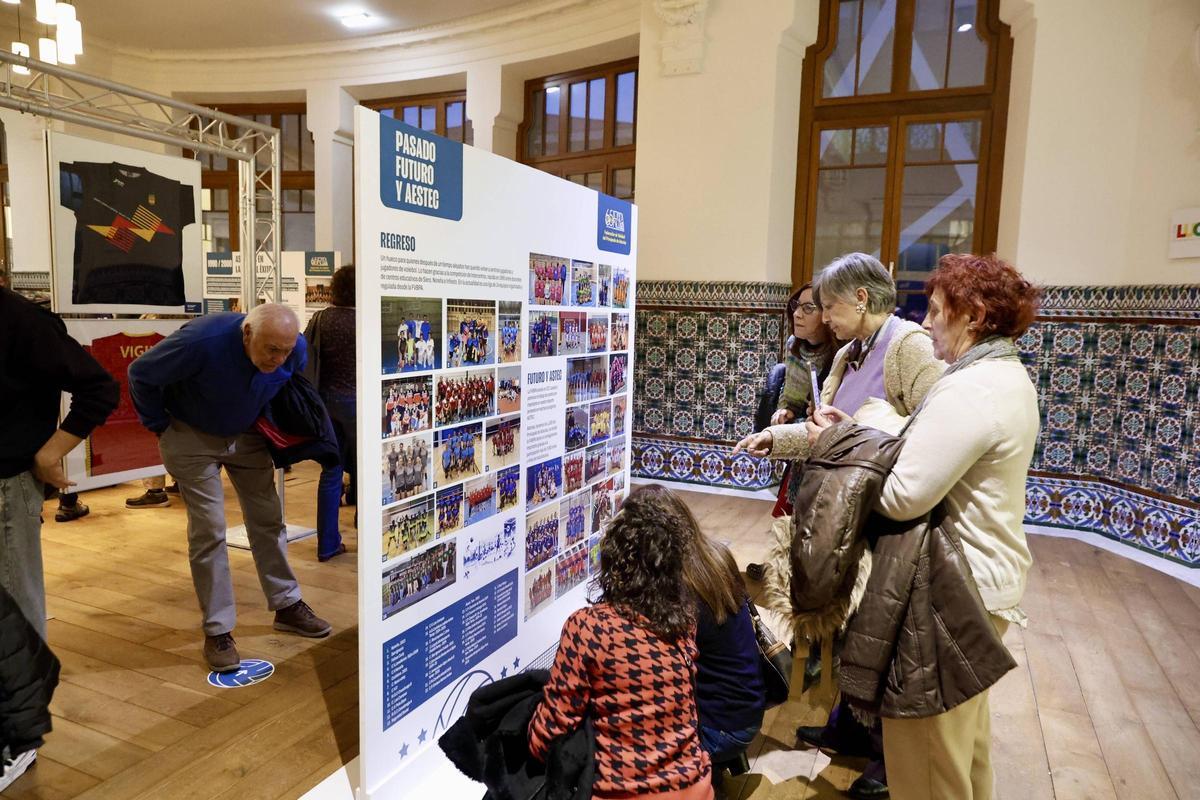 Visitantes observando uno de los paneles de la exposición.