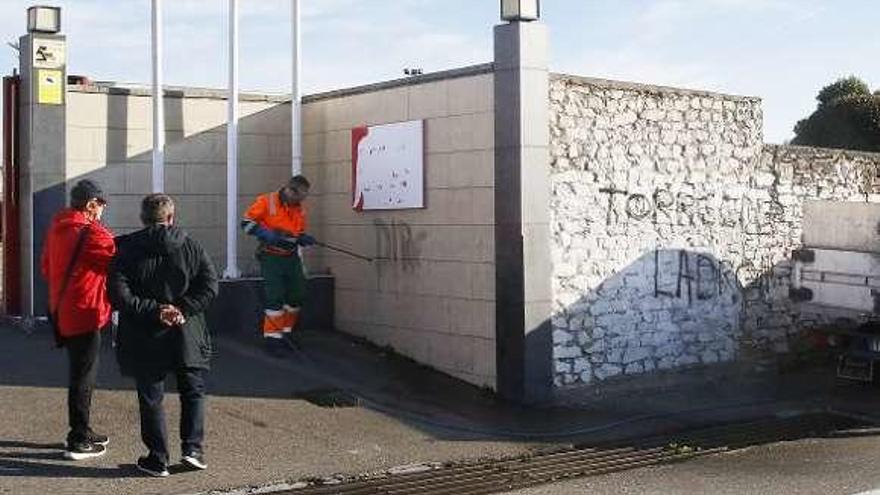 Operarios limpiando las pintadas en Mareo