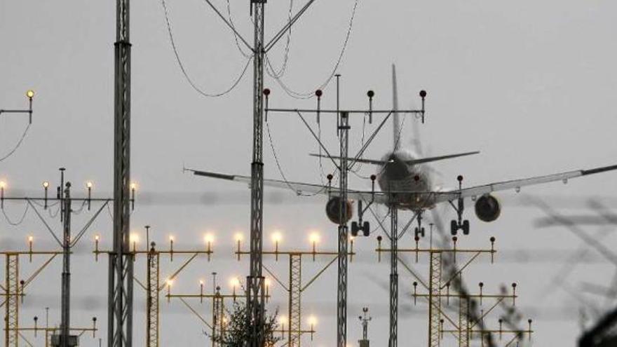 Un avión de la ruta Barcelona-Vigo aterriza ayer en Peinador; en primer término, el sistema ILS.  // J. Lores