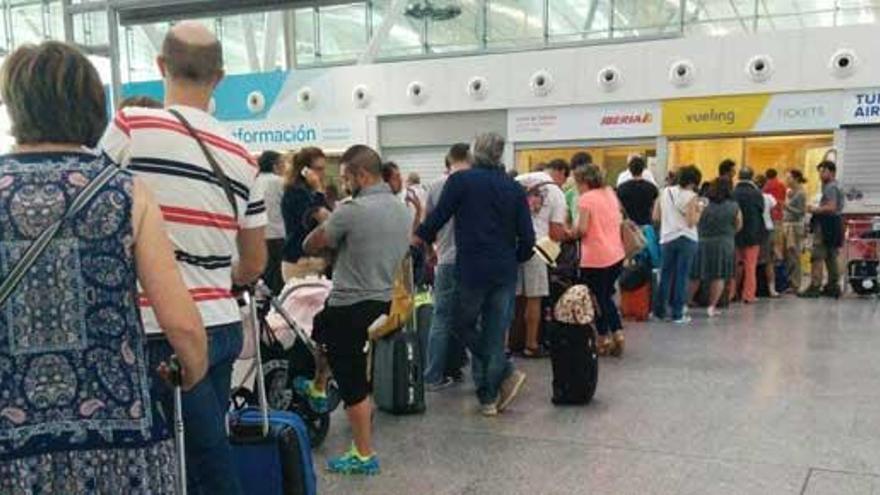 Cientos de personas hacen cola frente al mostrador de Vueling.