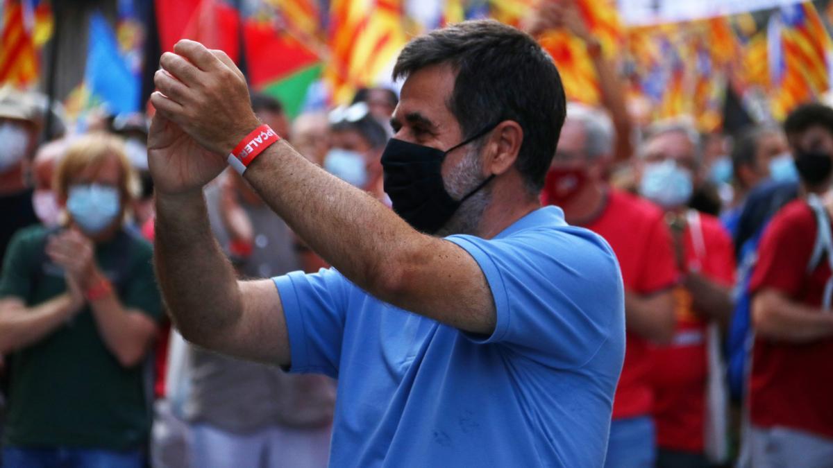 Jordi Sànchez (Junts) saludant als manifestants davant la capçalera de la manifestació de la Diada, amb milers de persones al darrere.