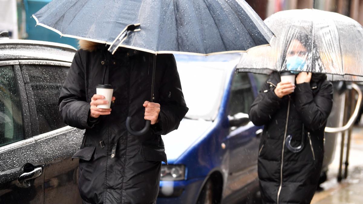 Jóvenes con paraguas durante una jornada lluviosa en A Coruña.
