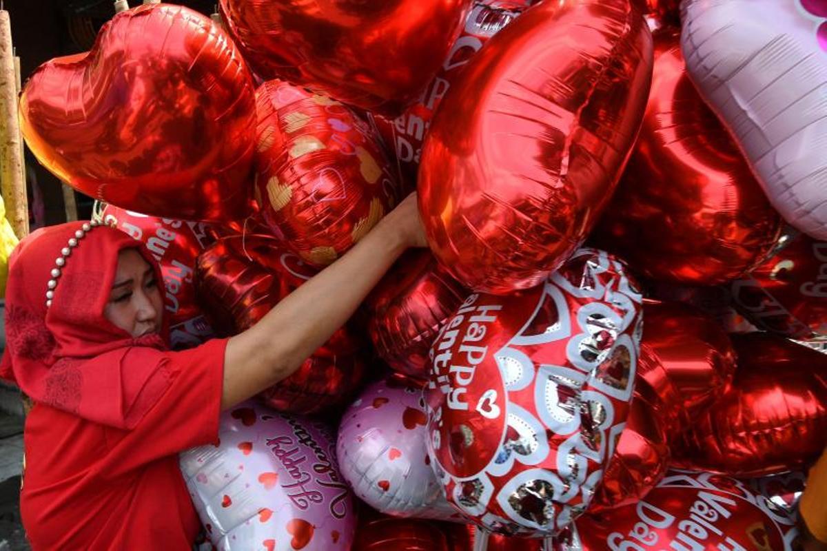 La gente compra ramos de flores el Día de San Valentín en un mercado de flores en Manila