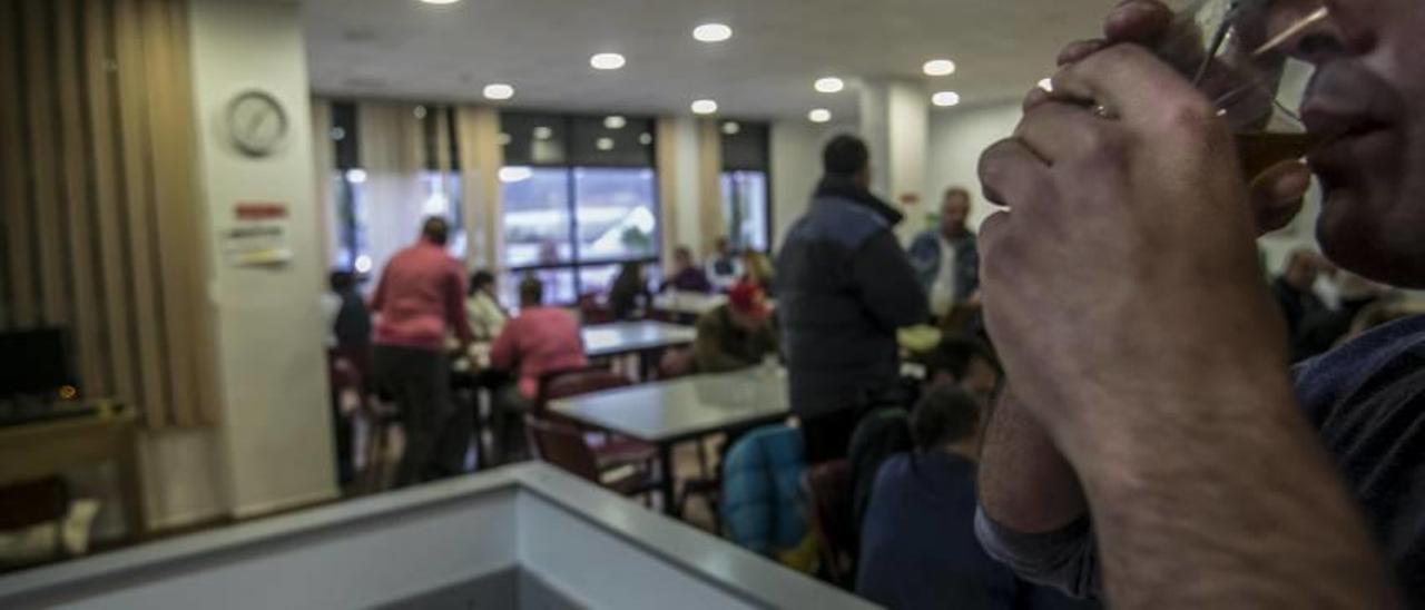 Una trabajadora social atendiendo ayer por la tarde en Cáritas, donde también se presta acompañamiento familiar. Sobre estas líneas, personas que se dan apoyo mutuo en la sede de la ONG, ayer.