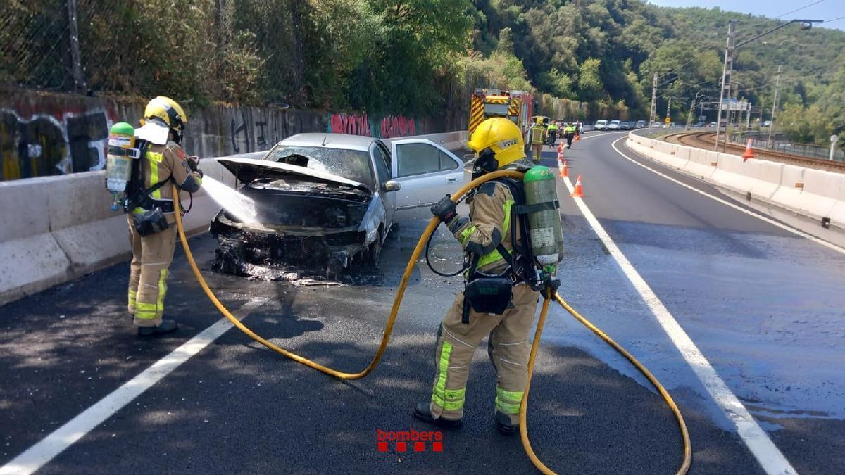 Bombers apagant el foc del vehicle incendiat a Celrà