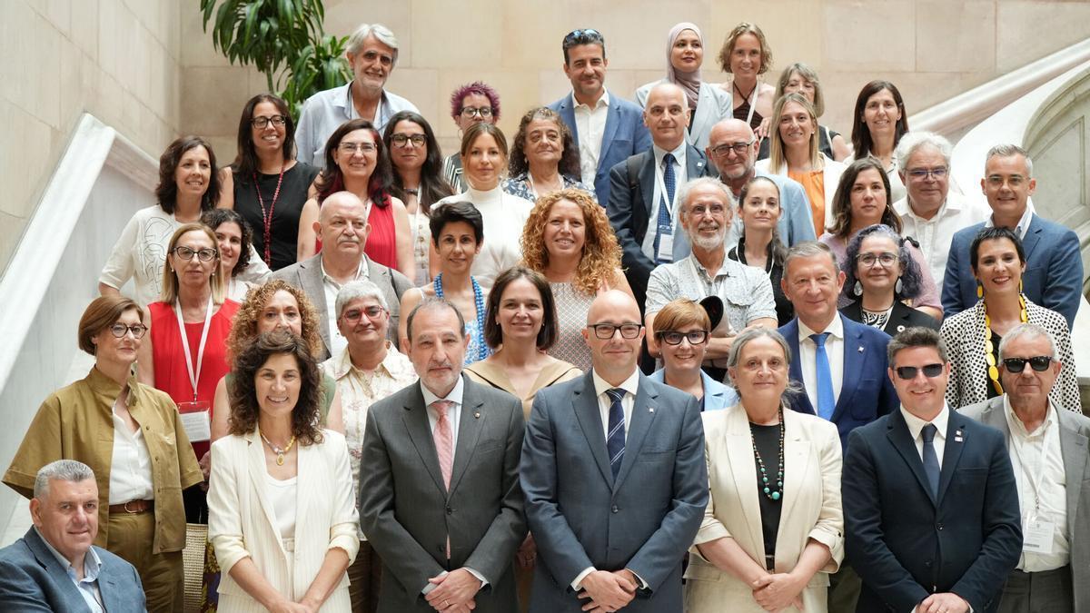 Los consejeros Ramon Espadaler y Raúl Moreno posan para una fotografía junto a otros diputados y representantes de asociaciones en la escalinata del Parlamento.