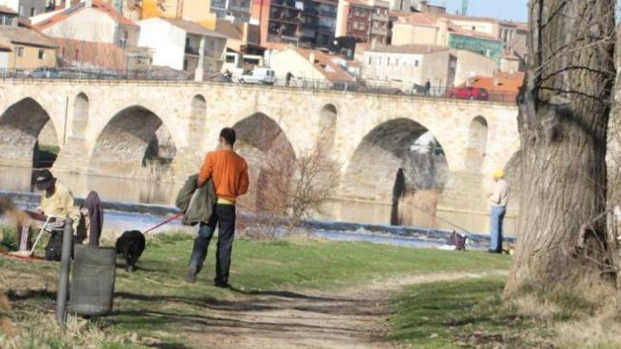 Algunos paseantes, ayer, en la orilla del río Duero en su margen izquierda.