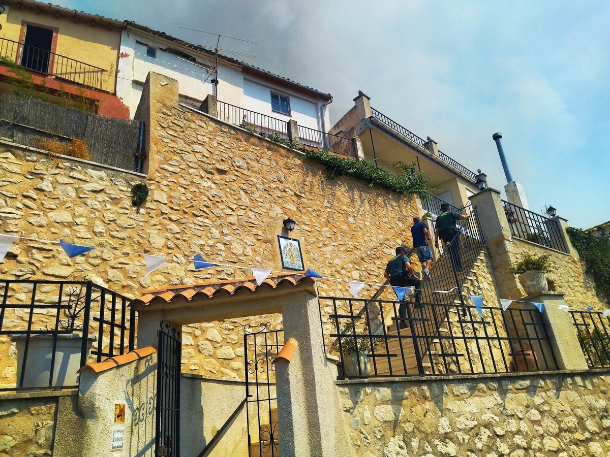La Guardia Civil sube a una de las casas para avisar a sus residentes de que tienen que desalojar el pueblo
