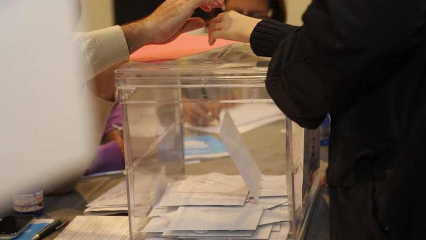 Una mujer introduce una papeleta en una urna durante unas elecciones.