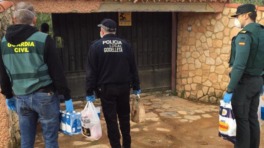 Agentes de la Policía Local de Godelleta y de la Guardia Civil llevan productos de primera necesidad a unos vecinos.