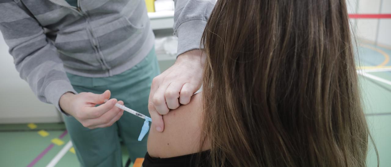 Un mujer recibe una dosis de la vacuna contra el coronavirus en el Polideportivo Germans Escalas