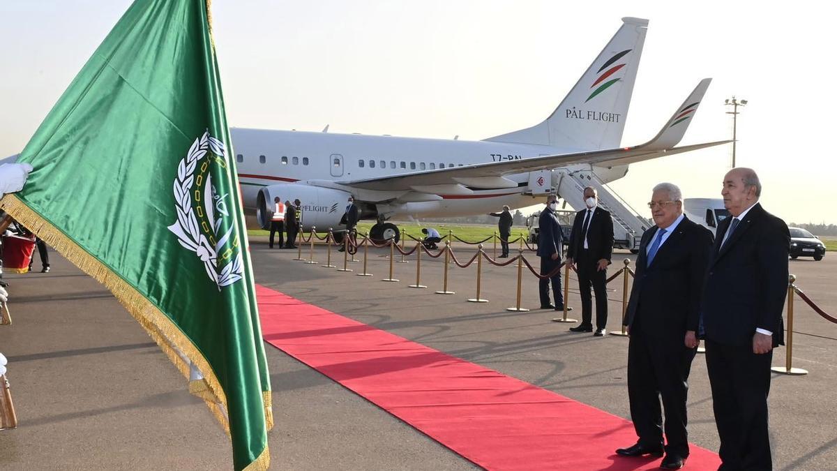 El presidente de Argelia, Abdelmadjid Tebboune (derecha), recibe al presidente de la Autoridad Nacional Palestina, Mahmud Abbás, este lunes en el aeropuerto de Argel.